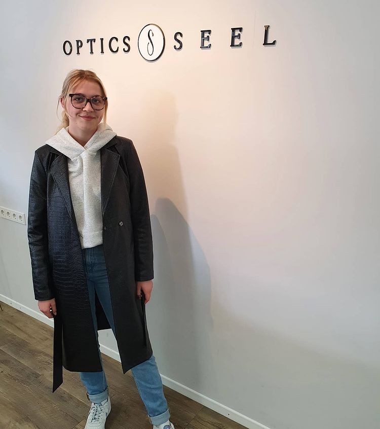 Frau mit Brille vor weißer Wand