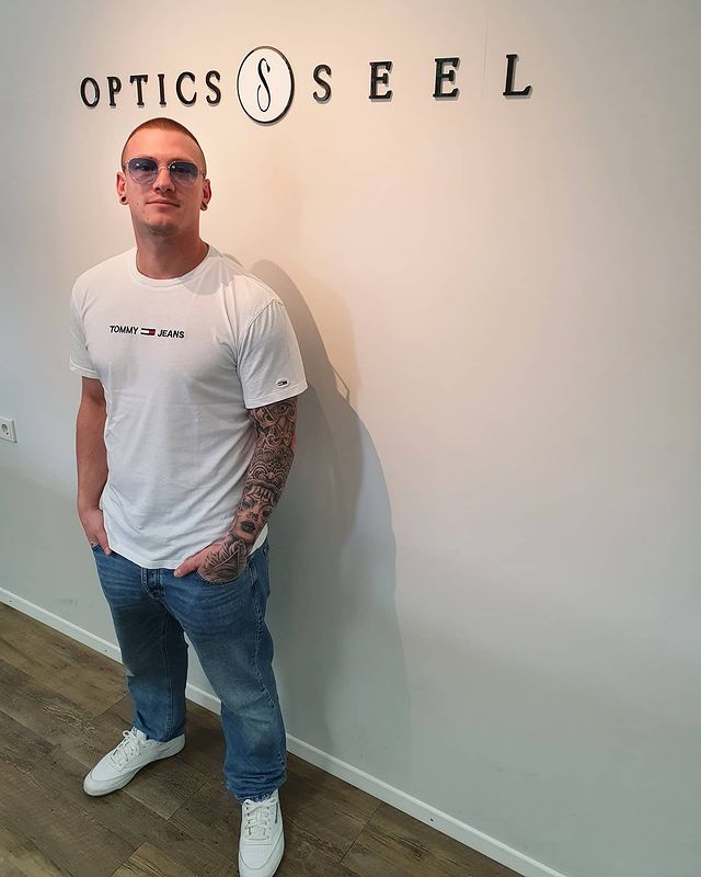 Mann mit Brille vor weißer Wand